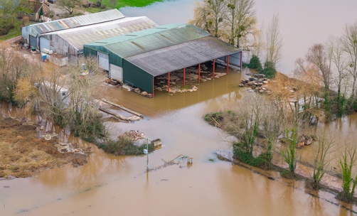 Aerial view of flooded farm buildings and fields in the UK